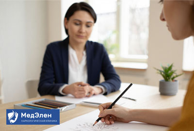 Пациент рисует, сидя за столом